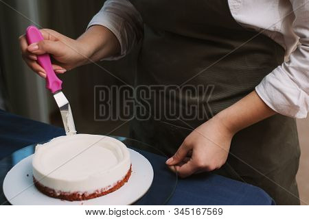 The Confectioner Levels The Cream On The Cake. The Cook Creates A Cake, Collects It And Covers It Wi