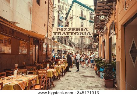 Palermo, Italy: Pizzeria And Trattoria Signs For Evening Customers On Narrow Street With People Walk
