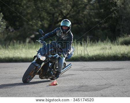 30-09-2019 Riga, Latvia. Motorcyclist On A Black Sports Motorcycle Rides On The Asphalt Ground