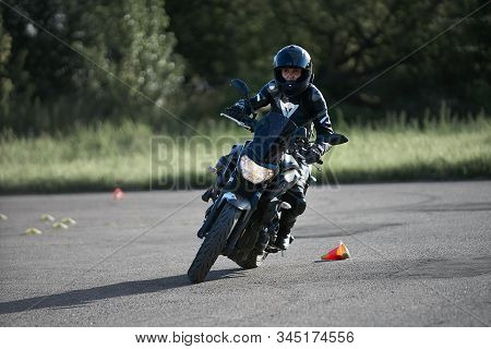 30-09-2019 Riga, Latvia. Motorcyclist On A Black Sports Motorcycle Rides On The Asphalt Ground