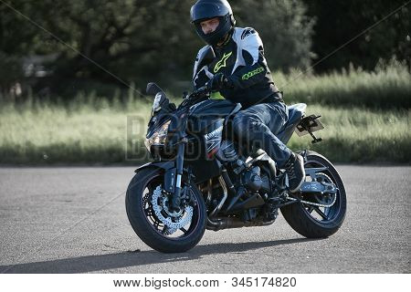 30-09-2019 Riga, Latvia. Motorcyclist On A Black Sports Motorcycle Rides On The Asphalt Ground