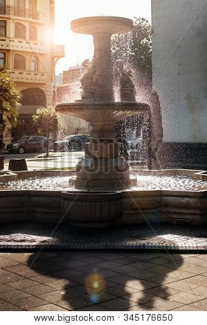 Drops Of Falling Water From A Sunny Back Light Fountain At City Park