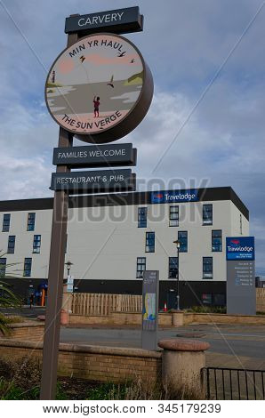 Rhyl, Uk: Jan 7, 2020:a Sign For The Sun Verge Public House Stands In Front Of The Travelodge Hotel 