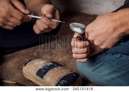 Two Shabby  Men Preparing Drug Injection In Slums.