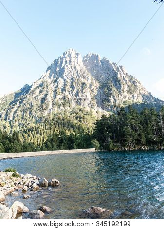 Pond Of Sant Maurici, In The Aiguestortes And Sant Maurici National Park. The Peak Amitges On Backgr