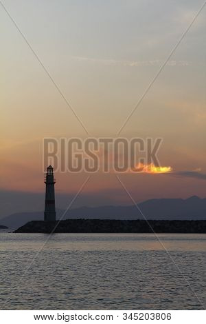 Seascape At Sunset. Lighthouse On The Coast. Seaside Town Of Turgutreis And Spectacular Sunsets