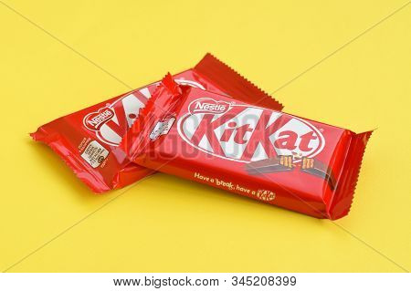 Kit Kat Chocolate Bar In Red Wrapping Lies On Yellow Background. Kit Kat Created By Rowntrees Of Yor