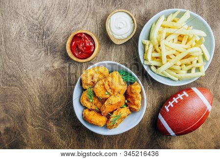Table Fof Tasty Snacks And Beer Prepared For Watching Sports On Tv. Wooden Background. Top View. Fla
