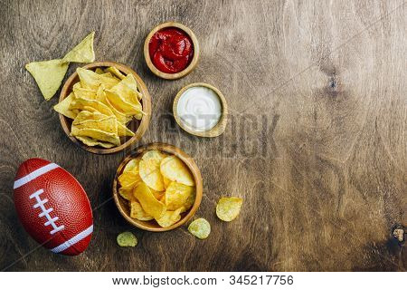 Table Fof Tasty Snacks And Beer Prepared For Watching Sports On Tv. Wooden Background. Top View. Fla