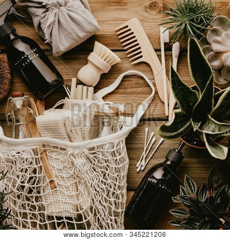 Collection of various succulent plants and Mesh market bag with bamboo cutlery, reusable bottles and eco cotton bags on wooden background