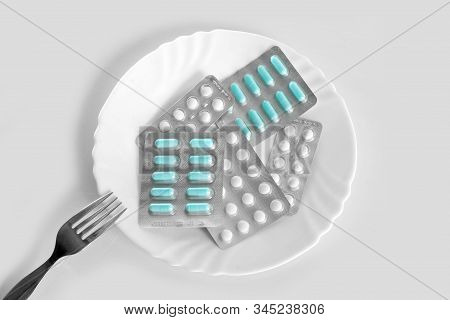 Different Pills On A Plate With Cutlery. The Concept Of Prescription Drugs For Weight Loss. Means Fo