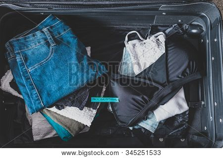 Luggage With Pile Of Clothes And Packing Everything Label On Them