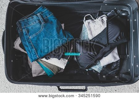 Luggage With Pile Of Clothes And Packing Everything Label On Them