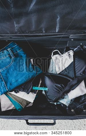 Luggage With Pile Of Clothes And Packing Everything Label On Them