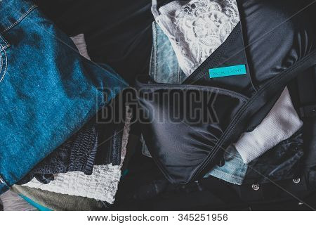 Travel Essentials For A Holiday, Luggage With Few Clothes Inside And Packing Light Label On Them