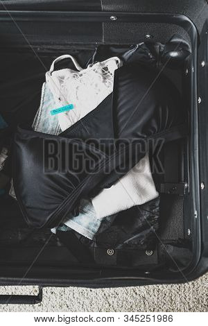 Luggage With Few Clothes Inside And Packing Light Label On Them