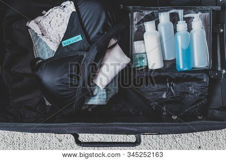 Luggage With Few Items Inside And Packing Light Label On Them