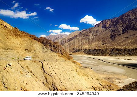 High Dynamic Range Image Of Barren Mountain In A Desert With River And Deep Blue Sky And White Patch