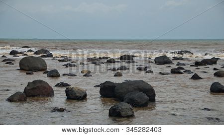 Fierce Waves On The Beach That Hit The Black Coral With Selective Focus.