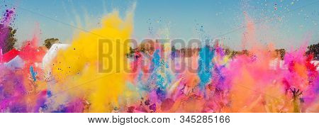 Diverse Crowd Throwing Bright Colored Powder Paint In The Air At Holi Festival Dahan Event