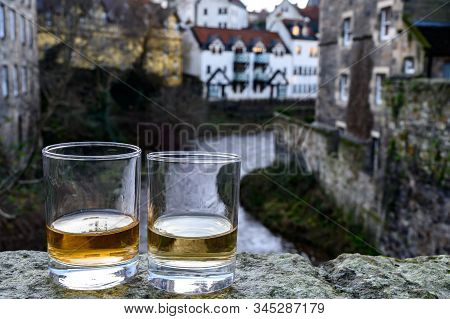 Scotch Single Malts Or Blended Whisky Spirits In Glasses With Old Houses Of Edinburgh On Background,