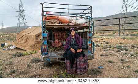 Shiraz, Iran - May 2019: Qashqai Woman Sitting By An Old Car. The Qasqhai Are Nomadic People Living 
