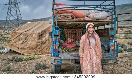 Shiraz, Iran - May 2019: Beautiful Qashqai Woman Sitting By An Old Car. The Qasqhai Are Nomadic Peop