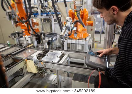 Man Programming Robot In Automotive Industrial, Professional Programmer, Industry Concept
