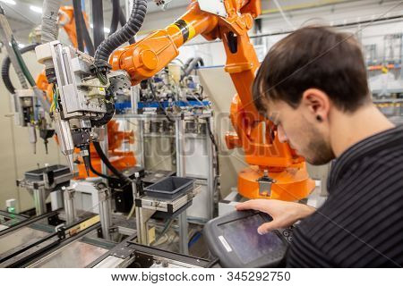 Man Programming Robot In Automotive Industrial, Professional Programmer, Industry Concept