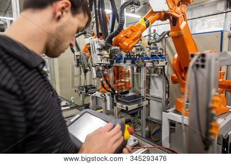 Man Programming Robot In Automotive Industrial, Professional Programmer, Industry Concept