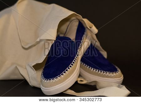 On Black Background Of The Shopping Bag, Shopper, Of Beige Cloth And Blue Slipons Of Suede. Street F