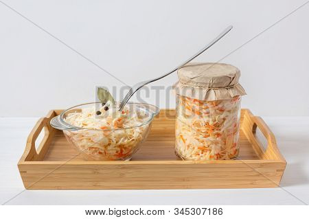 Homemade Sauerkraut. Fermented Food. Sauerkraut With Carrots In A Glass Jar And Bowl In A Wooden Tra