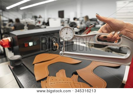 Woman Hands Use Leather Thickness Gauge On With A Natural Brown Leather. Preparing Of The Raw Materi