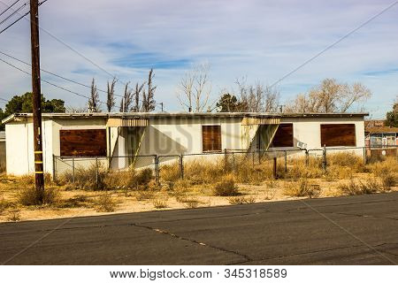 Overgrown Abandoned Duplex With Boarded Up Windows