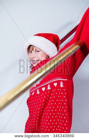 Charming Boy Wearing Santa's Hat In Red Sweater