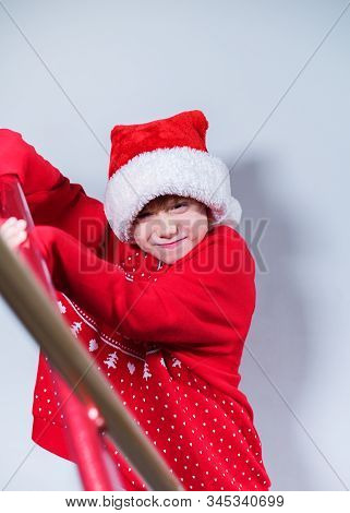 Charming Boy Wearing Santa's Hat In Red Sweater
