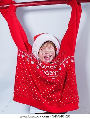 Charming Boy Wearing Santa's Hat In Red Sweater