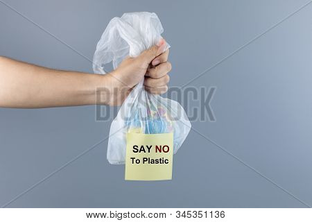 Man Holding Plastic Bag And Globe Inside Against Gray Background With Copy Space For Text. Environme