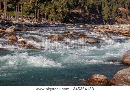 A Small Creek Flowing Through The Valleys Of The Himalayan Mountains With Big Rocks And Pebbles