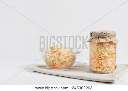 Homemade Sauerkraut. Fermented Food. Sauerkraut With Carrots In Glass Jar And Bowl With Fork On Wood