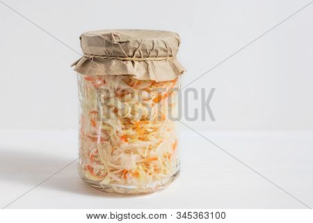 Homemade Sauerkraut. Fermented Food. Sauerkraut With Carrots In A Glass Jar On A White Wooden Backgr