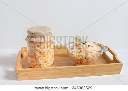 Homemade Sauerkraut. Fermented Food. Sauerkraut With Carrots In A Glass Jar And Bowl In A Wooden Tra