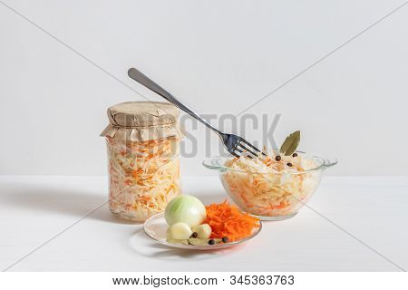 Homemade Sauerkraut With Carrots In A Glass Jar And Bowl On A White Wooden Background. Fermented Foo