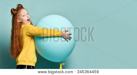 Ginger Teenage Kid With Fancy Hairstyle In Yellow Sweatshirt. Smiling, Holding Balloon, Posing Sidew