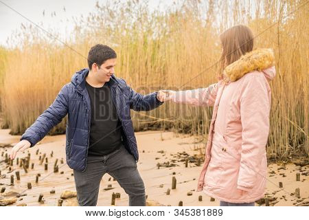 A Young Couple Romps Happily Around On A Beach