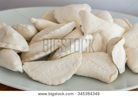 Raw Frozen Uncooked Dumplings On White Plate.