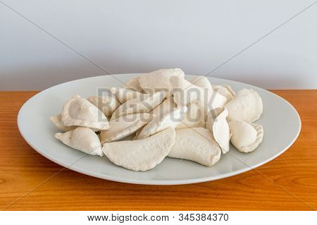 View On Raw Frozen Dumplings On White Plate.