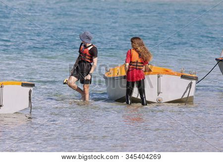 A Guy And A Girl Are Preparing To Go To Sea On A Boat