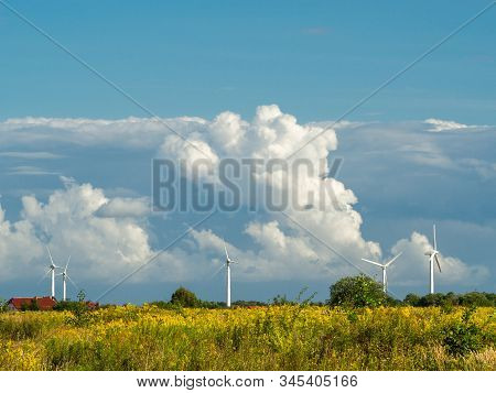 Wind Turbine Farm At The Field With Stormy Clouds. Wind Power For Electricity, Clean Energy. Baltic 