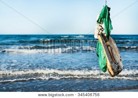 closeup of some used plstic objects in a fish hook, freshly fished in the ocean